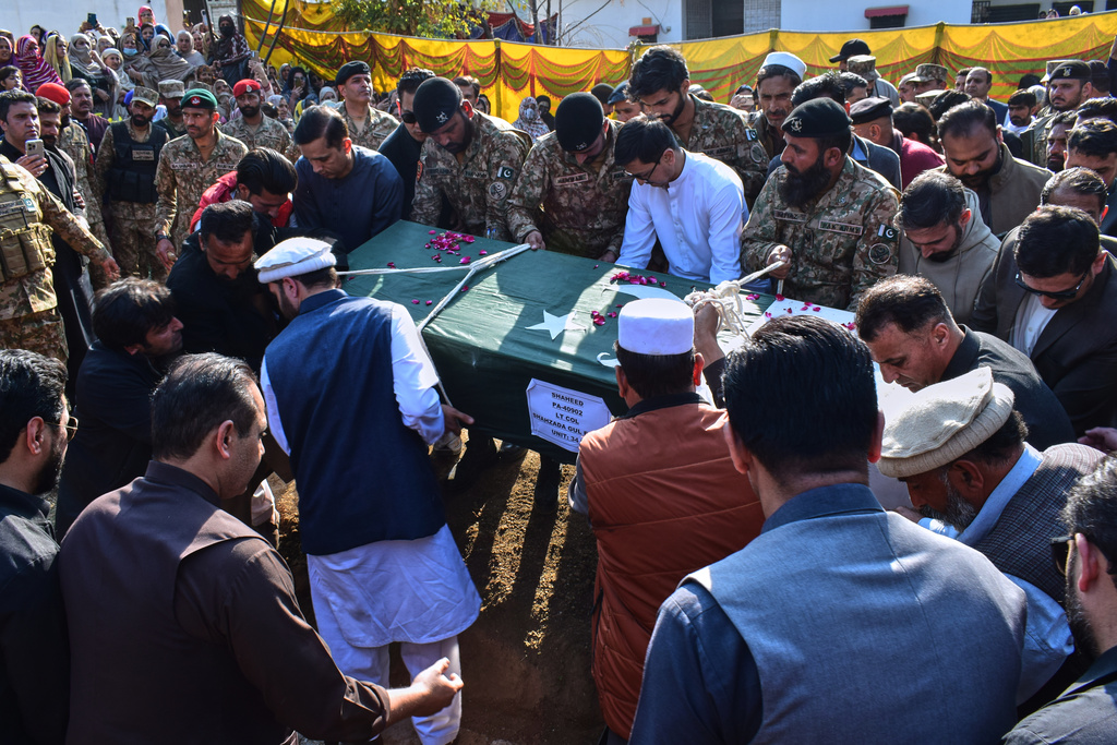 Relatives and army soldiers carry the casket of an army officer, who was killed in the suicide bombing in the border district of Bannu, for his burial following a funeral prayer in Mansehra, Pakistan, Sunday, Feb. 22, 2026. (AP Photo/Saqib Manzoor)