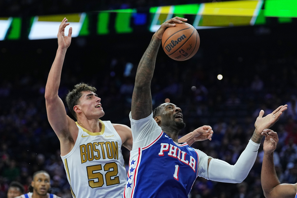 Philadelphia 76ers' Andre Drummond (1) wins the rebound over Boston Celtics' Luka Garza during the first half of an NBA basketball game Tuesday, Nov. 11, 2025, in Philadelphia. (AP Photo/Matt Rourke)