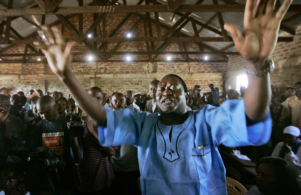 Kenyan opposition leader Raila Odinga raises his hands to excited supporters as he attends church service at St Michael's church in his home village of Bondo, near Kisumu, in Kenya, Sunday, Feb. 3, 2008. (AP Photo/Ben Curtis)