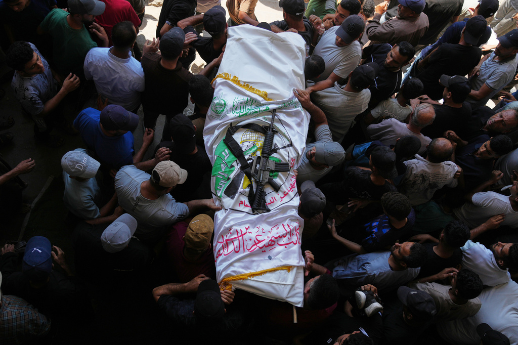 Palestinian mourners carry the body of Muhammad Yazouri, draped in the flag of the Mujahideen Brigades, a Palestinian militant group, with a rifle laid on top, during his funeral after he was killed in an Israeli airstrike the previous night, in Khan Younis, southern Gaza Strip, Friday, Sept. 11, 2026. (AP Photo/Jehad Alshrafi)