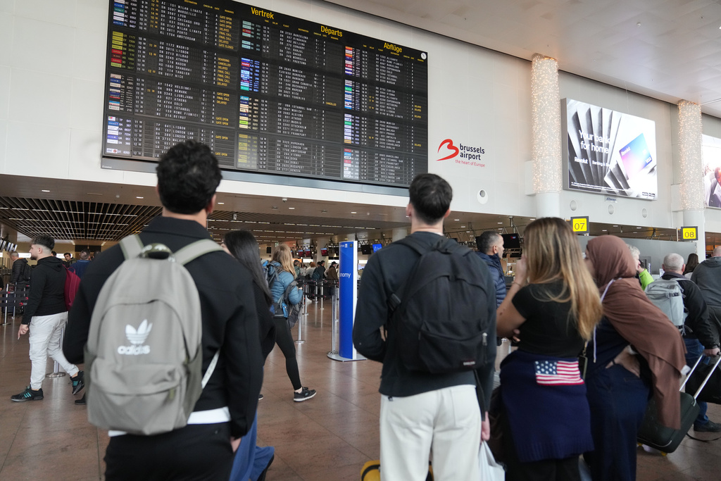 Passengers look at a departure board after several cancellations and delays due to reported overnight drone activity over Brussels International Airport in Zaventem, Wednesday, Nov. 5, 2025. (AP Photo/Virginia Mayo)