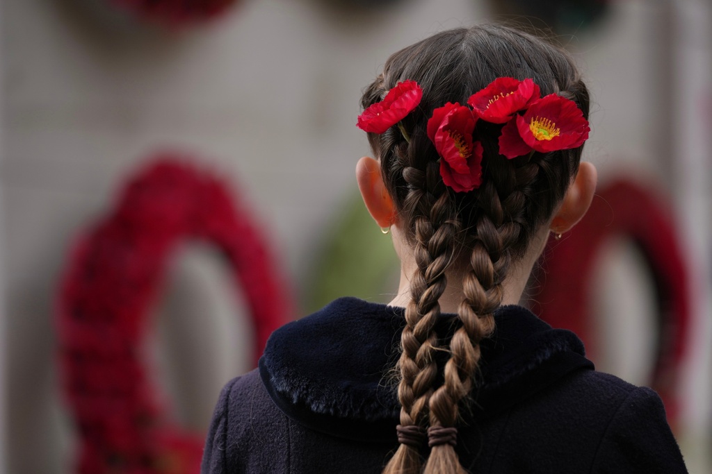 A girl attends the annual Service of Remembrance at The Cenotaph on Armistice Day in London, Tuesday, Nov. 11, 2025. (AP Photo/Kin Cheung)