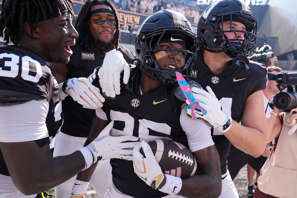 Vanderbilt cornerback Cayden Daniels, second from right, celebrates his touchdown with teammates during the second half of an NCAA college football game against North Carolina State, Saturday, Sept. 19, 2026, in Nashville, Tenn. (AP Photo/George Walker IV)