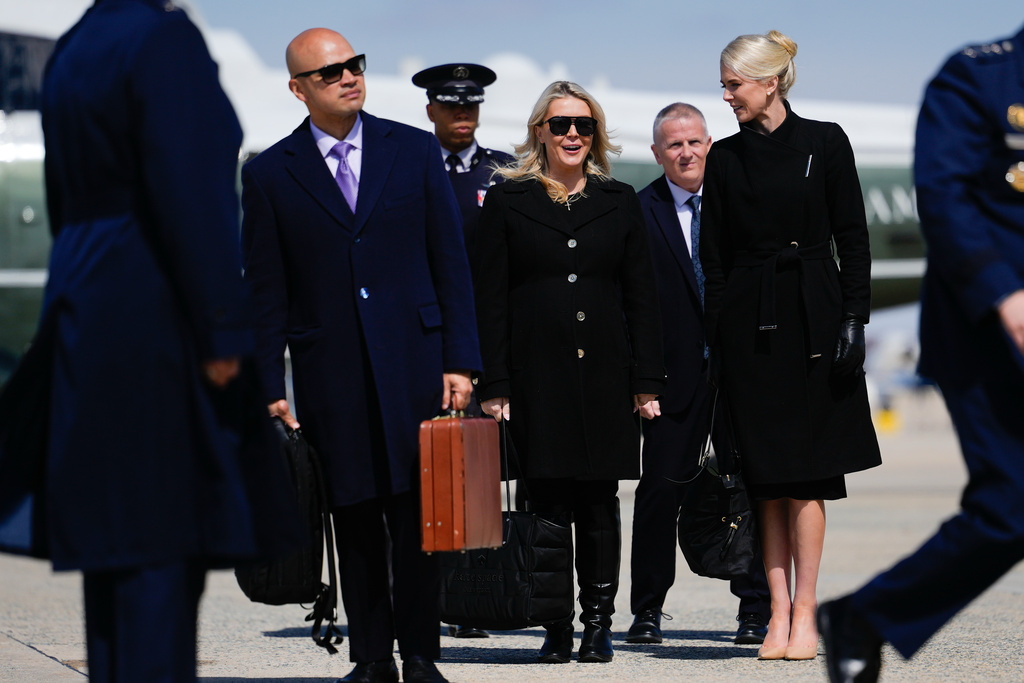 Personal aide to President Donald Trump Walt Nauta, White House press secretary Karoline Leavitt and White House aide Natalie Harp watch President Donald Trump boards Air Force One, Wednesday, March 18, 2026, at Joint Base Andrews, Md. (AP Photo/Julia Demaree Nikhinson)