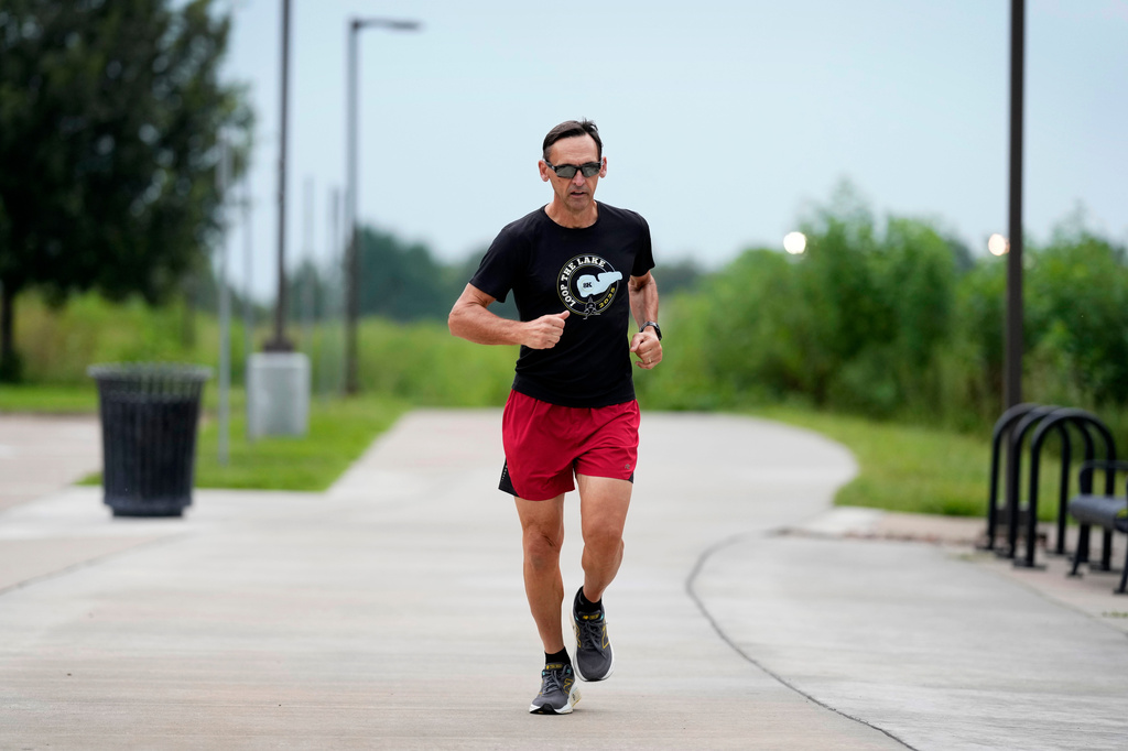 Paul Grinvalds, of West Des Moines, Iowa, warms up before running with the Raccoon River Running Club, Sunday, Aug. 9, 2026, in West Des Moines, Iowa. (AP Photo/Charlie Neibergall)