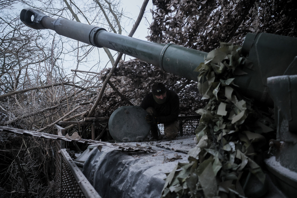 In this photo provided by Ukraine's 24th Mechanized Brigade press service, servicemen fire a 2S1 Gvozdika self propelled howitzer towards Russian positions near Chasiv Yar town, Donetsk region, Ukraine, Sunday, Jan. 18, 2026. (Oleg Petrasiuk/Ukraine's 24th Mechanized Brigade via AP)