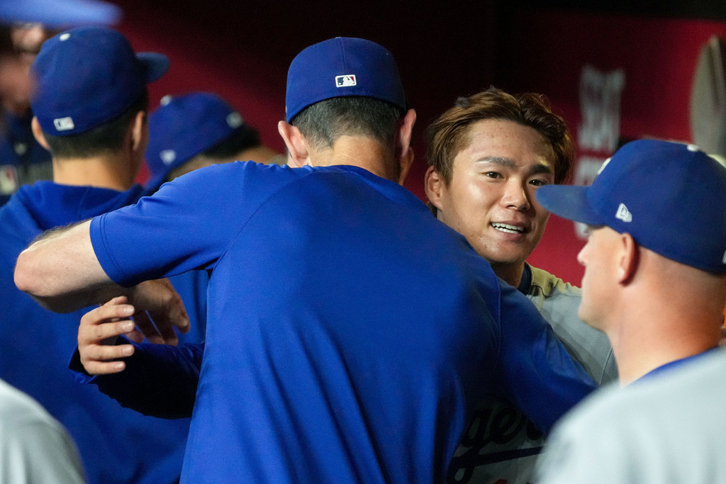 Los Angeles Dodgers pitcher Yoshinobu Yamamoto, right, gets a hug from his pitching coach Mark Prior, left after pitching six scoreless innings against the Arizona Diamondbacks during a baseball game Thursday, Sept. 25, 2025, in Phoenix. (AP Photo/Darryl Webb)