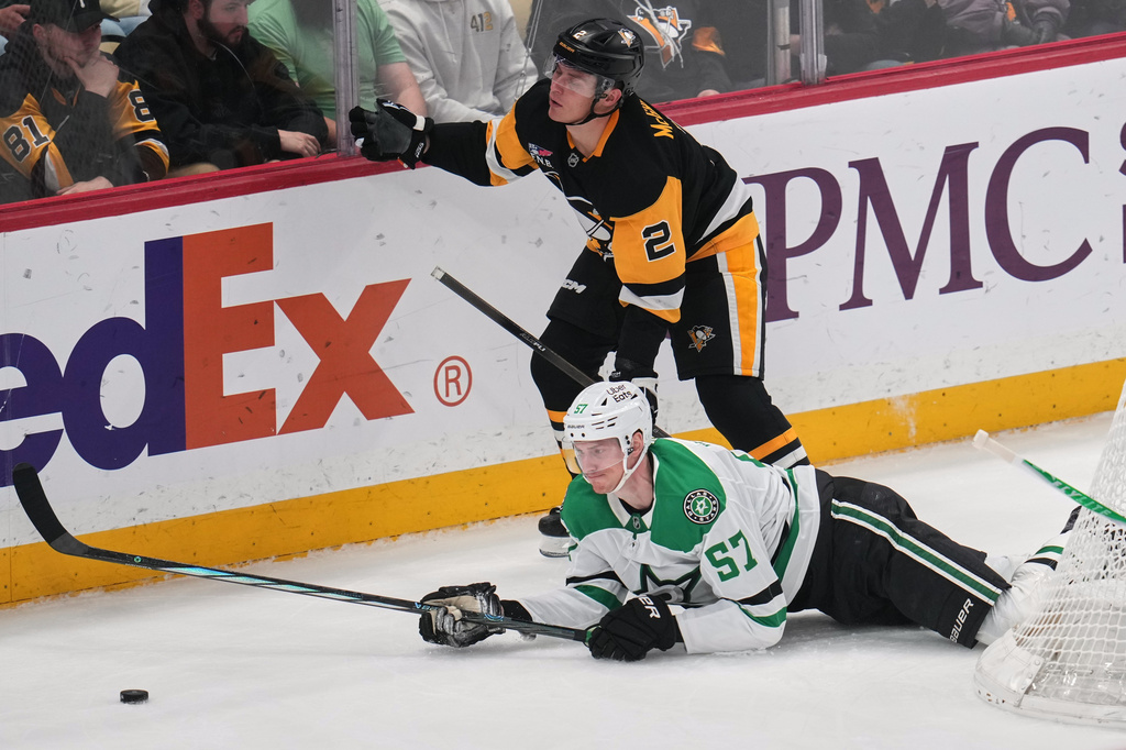 Pittsburgh Penguins' Rutger McGroarty (2) trips Dallas Stars' Tyler Myers (57) during the first period of an NHL hockey game in Pittsburgh, Saturday, March 28, 2026. (AP Photo/Gene J. Puskar)