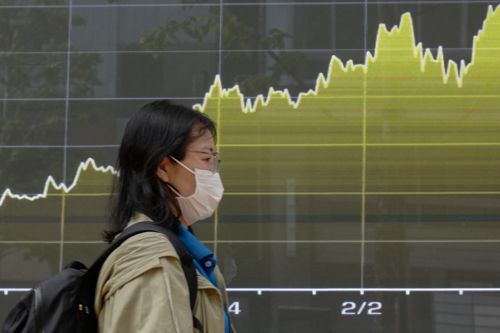 A person walks in front of an electronic stock board showing Japan's Nikkei index at a securities firm Tuesday, April 28, 2026, in Tokyo. (AP Photo/Eugene Hoshiko)