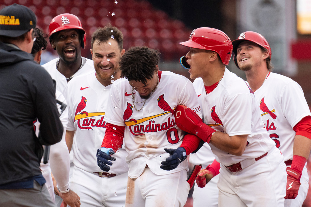 St. Louis Cardinal teammates surround Masyn Winn after he hit the game winning hit during the eleventh inning of a baseball game against the New York Mets Wednesday, April 1, 2026, in St. Louis. (AP Photo/LG Patterson)