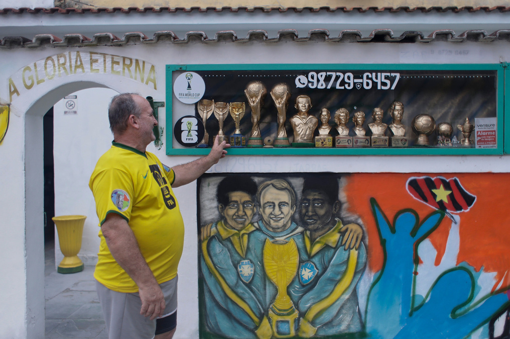 Jarbas Meneghini Carlini shows off FIFA World Cup trophy replicas he made, now decorations in front of his house, in Rio de Janeiro, Friday, May 15, 2026. (AP Photo/Bruna Prado)
