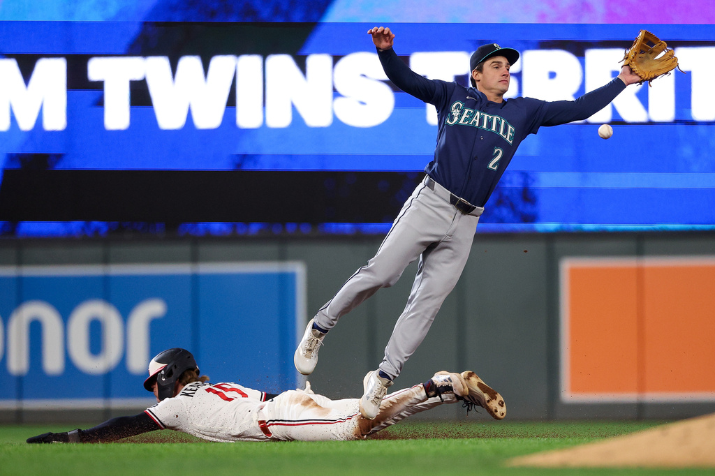 Minnesota Twins' Luke Keaschall, left, steals second base as Seattle Mariners second baseman Cole Young attempts to field the ball during the sixth inning of a baseball game, Tuesday, April 28, 2026, in Minneapolis. (AP Photo/Matt Krohn)