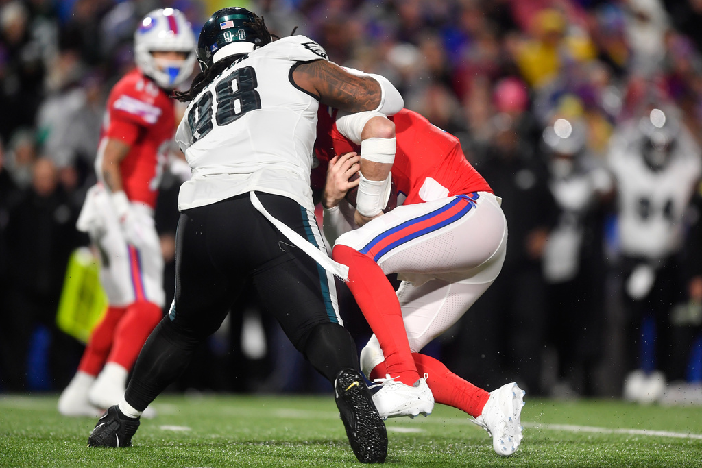 Philadelphia Eagles' Jalen Carter, left, sacks Buffalo Bills' Josh Allen during the first half of an NFL football game, Sunday, Dec. 28, 2025, in Buffalo, N.Y. (AP Photo/Adrian Kraus)