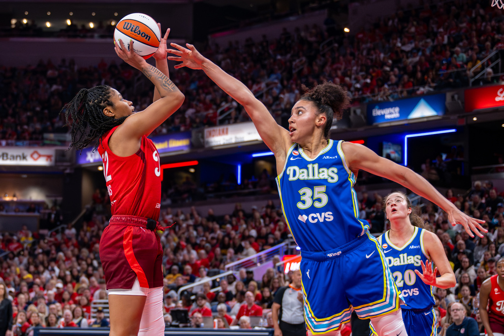 Indiana Fever guard Shatori Walker-Kimbrough (32) shoots over the defense of Dallas Wings guard Azzi Fudd (35) during the first half of an WNBA basketball in Indianapolis, Saturday, May 9, 2026. (AP Photo/Doug McSchooler)