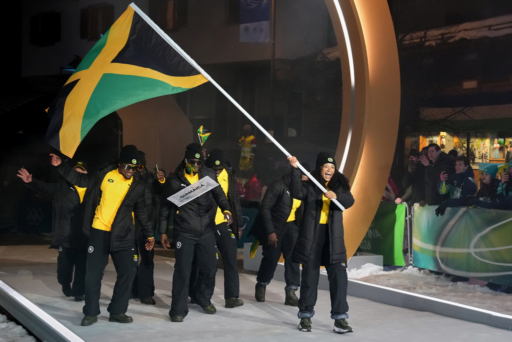 Mica Moore, flag bearer of Jamaica, leads her team in during the Olympic opening ceremony at the 2026 Winter Olympics, in Cortina d'Ampezzo, Italy, Friday, Feb. 6, 2026. (AP Photo/Misper Apawu)