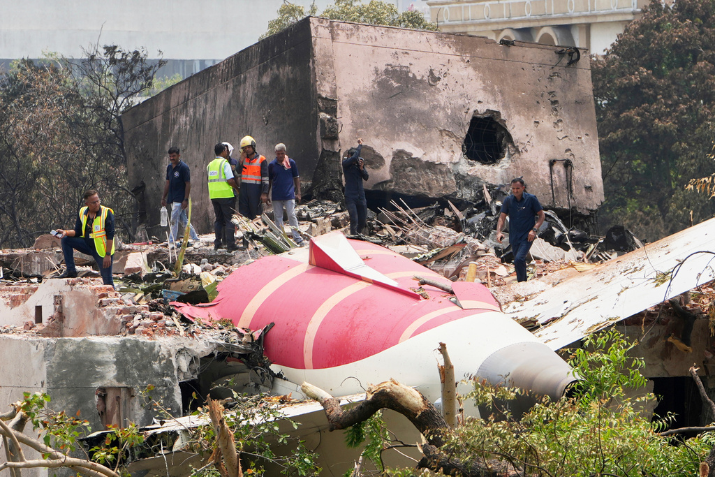 FILE - Officials inspect the site of Air India plane crash on the roof of a building in Ahmedabad, India, June 13, 2025. (AP Photo/Ajit Solanki, File)