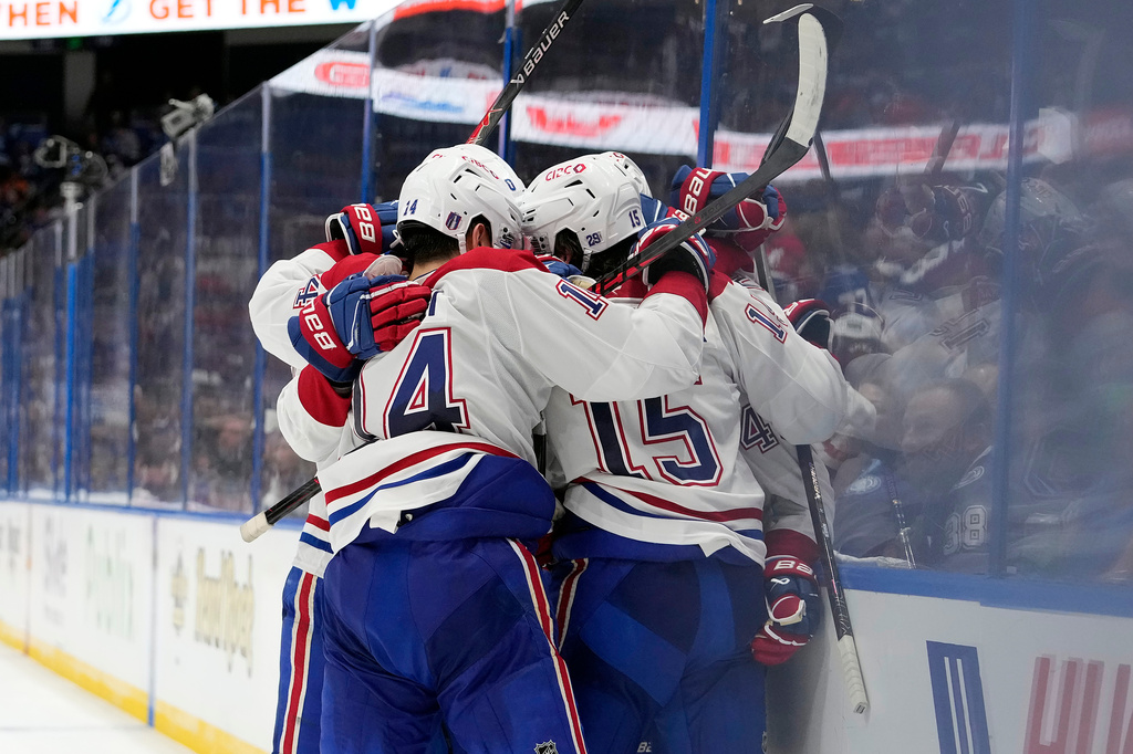 Montréal Canadiens center Alex Newhook (15) is mobbed by teammates, including Nick Suzuki (14) after scoring against the Tampa Bay Lightning during the third period in Game 7 of an NHL hockey Stanley Cup first-round playoff series, Sunday, May 3, 2026, in Tampa, Fla. (AP Photo/Chris O'Meara)