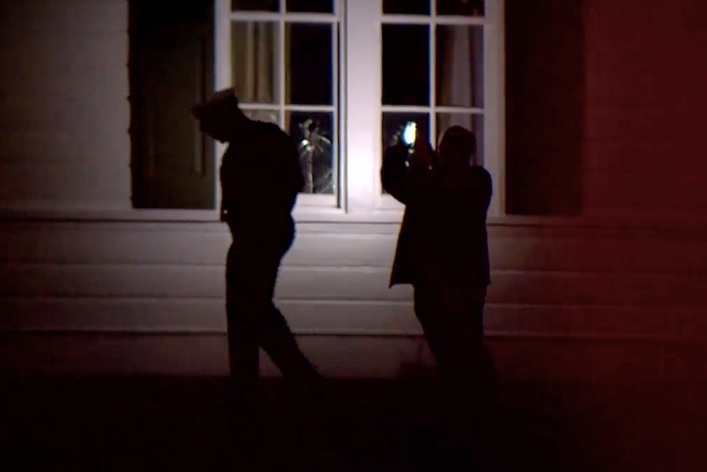 In this image taken from WCPO 9 News video shows officials inspecting broken windows and other property damage at Vice President JD Vance's Ohio home in eastern Cincinnati, Ohio, Monday, Jan. 5, 2026. (WCPO 9 News via AP)