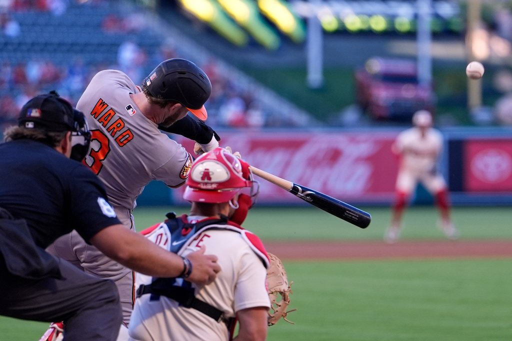 Baltimore Orioles' Taylor Ward, center, hits a solo home run as home plate umpire John Libka, left, and Los Angeles Angels catcher Logan O'Hoppe watch during the first inning of a baseball game Monday, June 22, 2026, in Anaheim, Calif. (AP Photo/Mark J. Terrill)