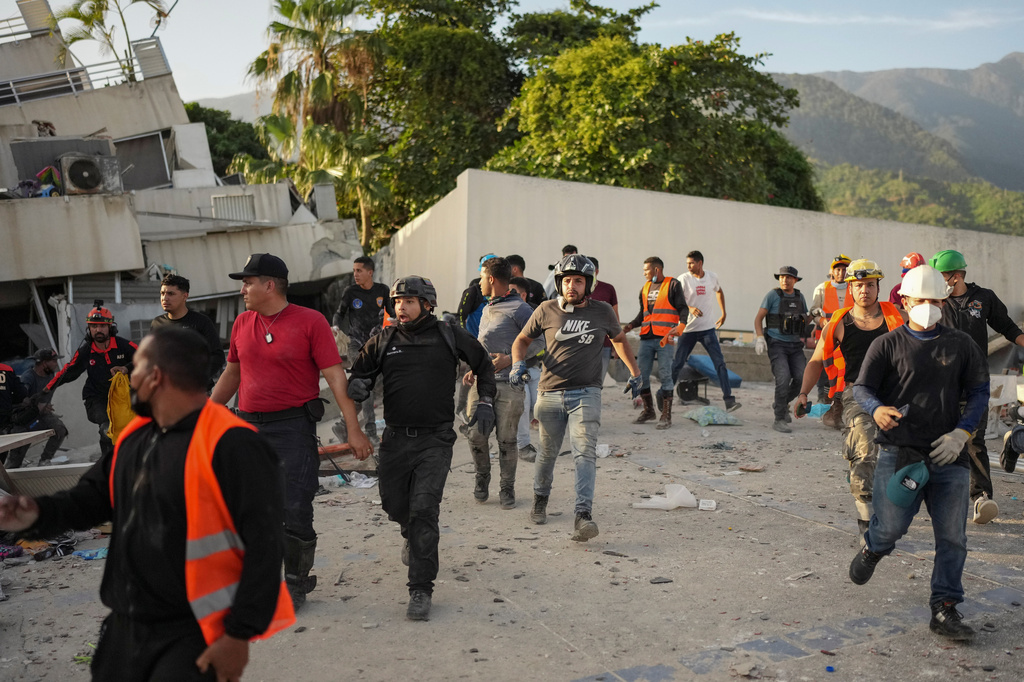 Residents and rescuers searching for survivors run as an aftershock shakes the area five days after back-to-back earthquakes struck La Guaira, Venezuela, Monday, June 29, 2026. (AP Photo/Matias Delacroix)