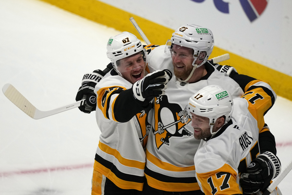 Pittsburgh Penguins right winger Anthony Mantha, center, is congratulated after scoring a goal by right wing Rickard Rakell, left, and right wing Bryan Rust in the first period of an NHL hockey game against the Colorado Avalanche, Monday, March 16, 2026, in Denver. (AP Photo/David Zalubowski)