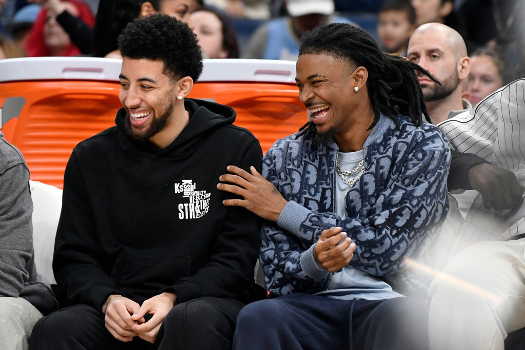 Memphis Grizzlies guards Scotty Pippen Jr., left, and Ja Morant, right, react from the bench in the first half of an NBA basketball game against the Sacramento Kings, Thursday, Nov. 20, 2025, in Memphis, Tenn. (AP Photo/Brandon Dill)
