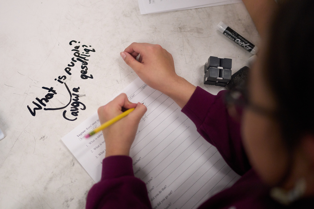 Ellyne Aliralria, a 10-year-old student displaced from her village of Kipnuk by ex-Typhoon Halong, fills out a worksheet in Yup'ik at College Gate Elementary, where students spend half their time learning in a Yup'ik language immersion program, Thursday, Oct. 30, 2025, in Anchorage, Alaska. (AP Photo/Lindsey Wasson)