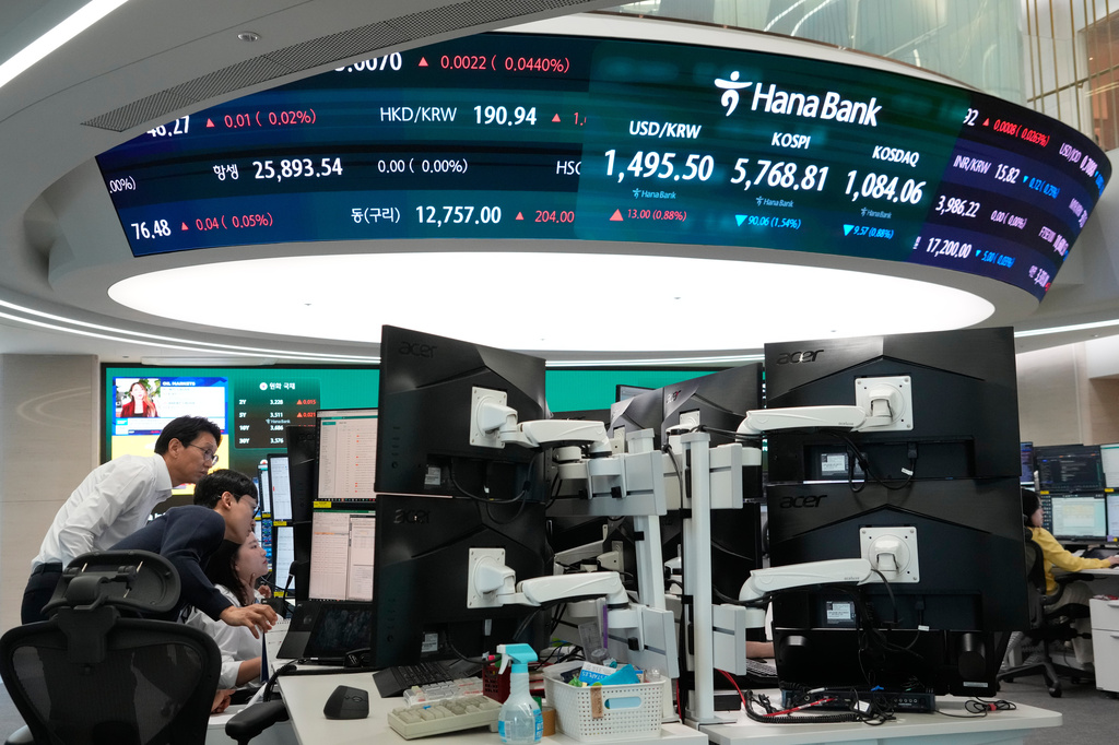Currency traders watch monitors near a screen showing the Korea Composite Stock Price Index (KOSPI), top center, and the foreign exchange rate between U.S. dollar and South Korean won, top center left, at the foreign exchange dealing room of the Hana Bank headquarters in Seoul, South Korea, Monday, April 13, 2026. (AP Photo/Ahn Young-joon)