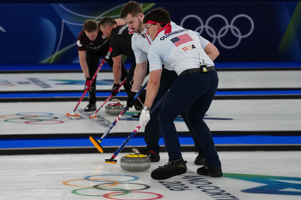 United States' Aidan Oldenburg, right, and Ben Richardson, left, and Canada's Ben Hebert, right, and Marc Kennedy, left, in action during the men's curling round robin session, at the 2026 Winter Olympics, in Cortina d'Ampezzo, Italy, Wednesday, Feb. 11, 2026. (AP Photo/Misper Apawu)