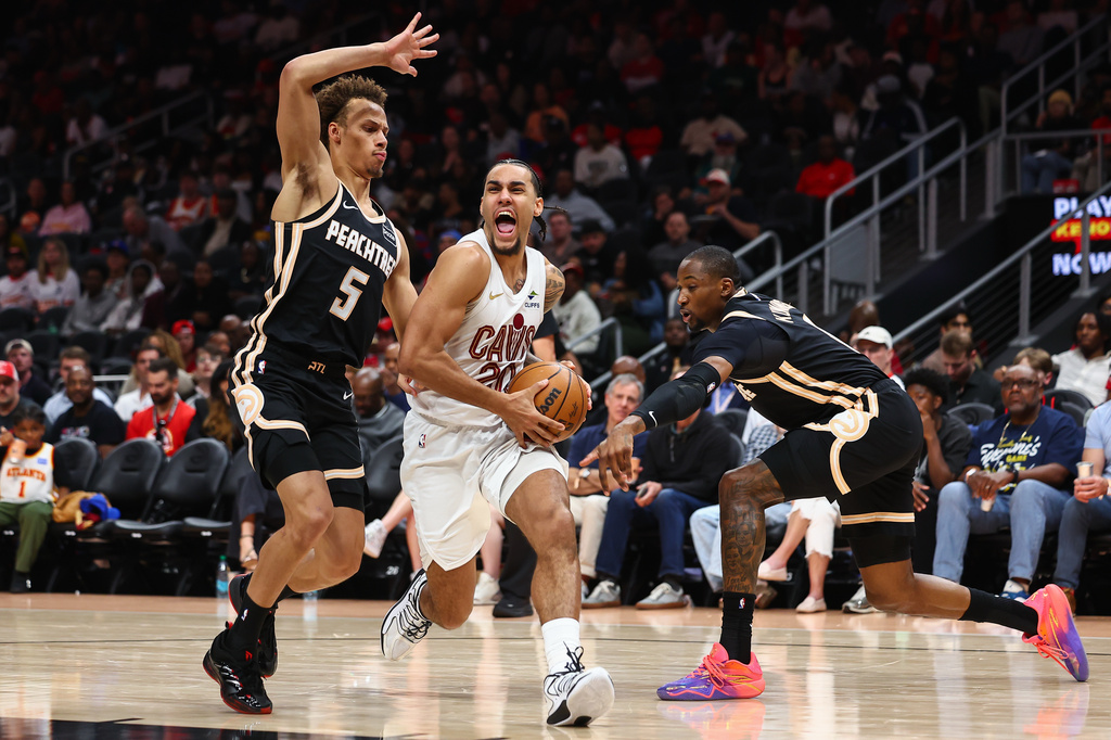 Cleveland Cavaliers guard Jaylon Tyson, center, drives to the basket against Atlanta Hawks guard Dyson Daniels, left, and forward Jonathan Kuminga, right, during the first half of an NBA basketball game, Friday, April 10, 2026, in Atlanta. (AP Photo/Colin Hubbard)