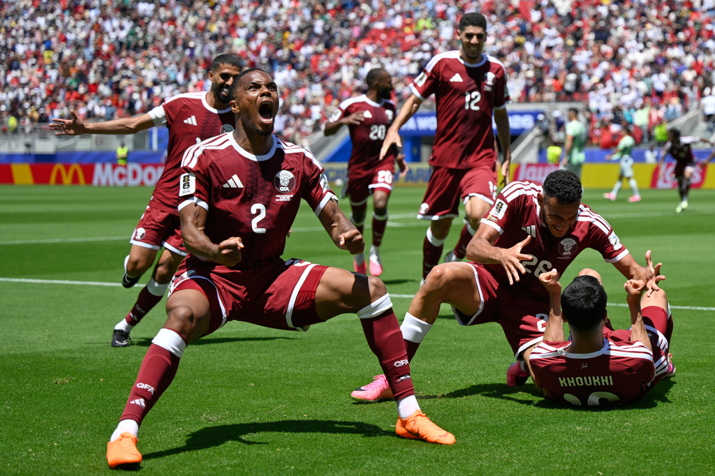 Qatar's Pedro Miguel, yells as he celebrates after teammate Qatar's Boualem Khoukhi, right scored his sides first goal during the World Cup Group B soccer match between Qatar and Switzerland in Santa Clara, Calif., near San Francisco, Saturday, June 13, 2026. (AP Photo/Eakin Howard)