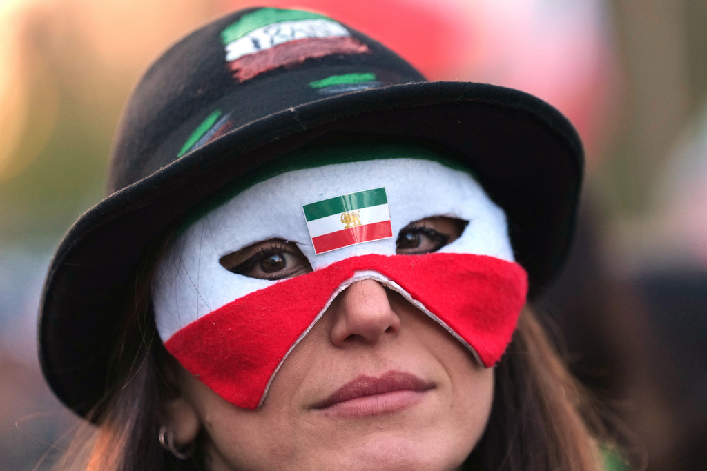 A protester wears a mask during a rally in London, Saturday, Feb. 28, 2026 after U.S. and Israeli forces carried out a series of strikes on Iran on Saturday morning. (AP Photo/Alastair Grant)