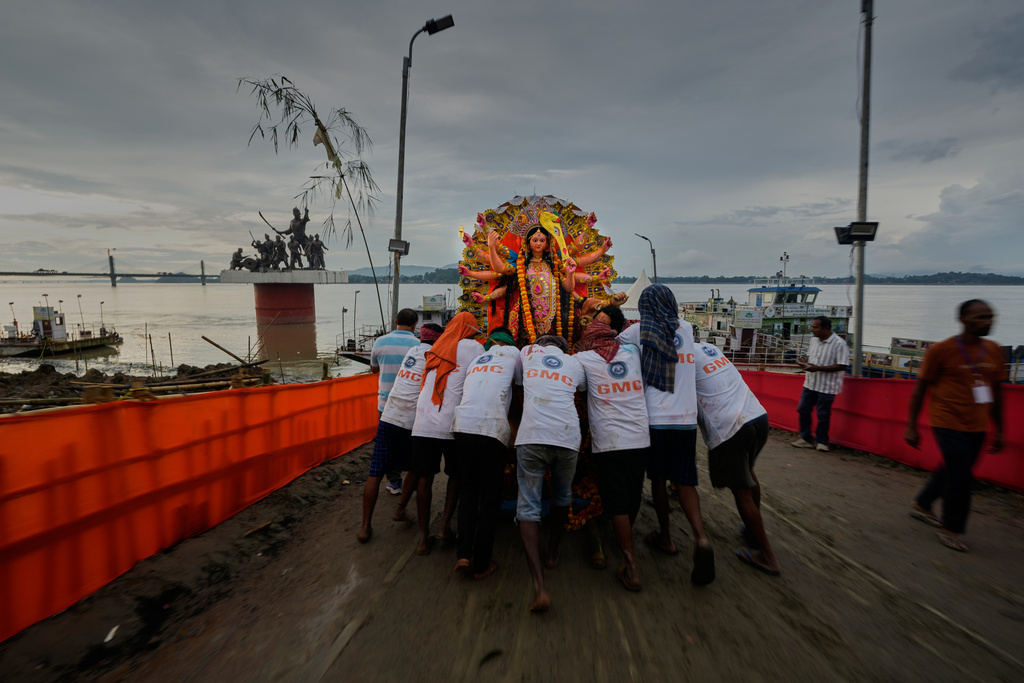 Municipal employees carry an idol of Hindu goddess Durga to emmers in river Brahmaputra in Guwahati, Thursday, Oct. 2, 2025. (AP Photo/Anupam Nath)