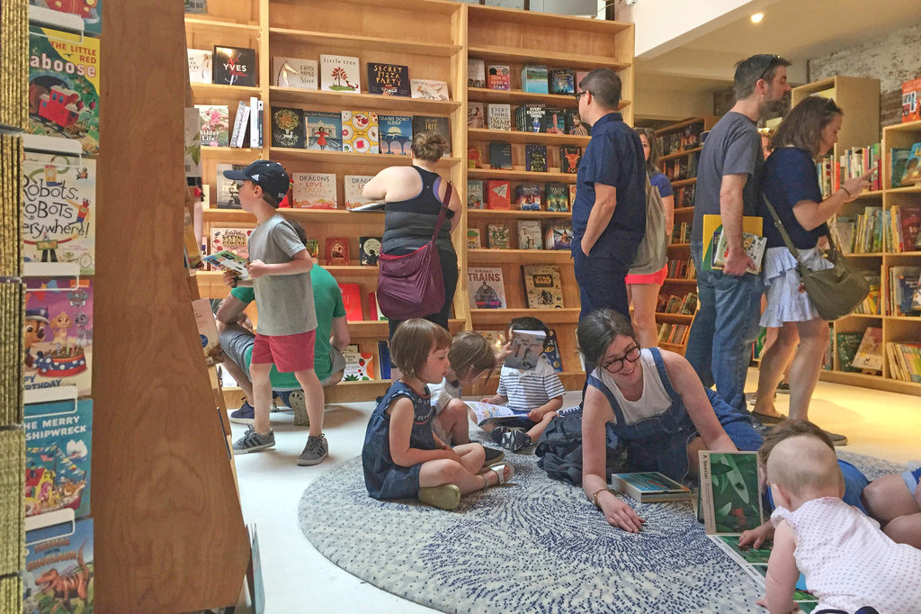 FILE - Customers appear in the children's area of the Books Are Magic bookstore, owned by author Emma Straub, in Brooklyn, New York, on April 29, 2017. (AP Photo/Beth J. Harpaz, File)