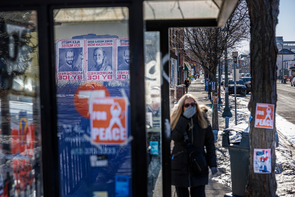 Posters depicting Alex Pretti and Renee Nicole Good are displayed inside a bus shelter across the street from the site where Pretti, a 37-year-old ICU nurse, was fatally shot by federal immigration agents, in Minneapolis, Minn., Thursday, Jan. 29, 2026. (Kerem Yücel/Minnesota Public Radio via AP)