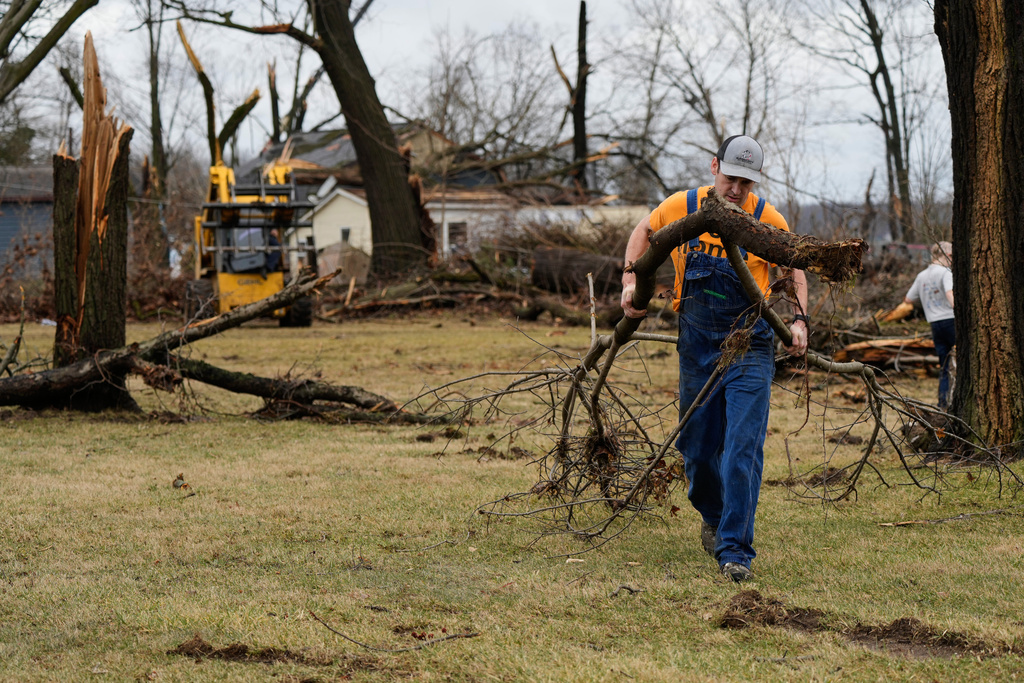 A volunteer clears felled branches after a suspected tornado hit the area a day earlier, in Union City Mich., Saturday, March 7, 2026. (AP Photo/Nam Y. Huh)