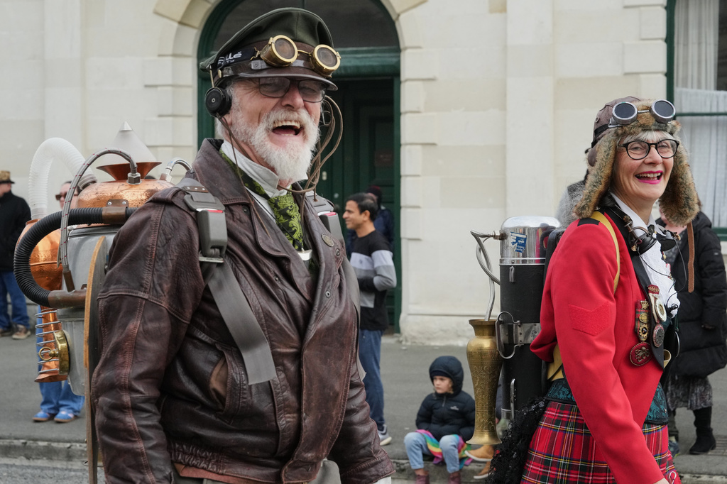 Steampunk NZ Festival co-founders Iain Clark, who goes by Agent Darling, and Helen Jansen walk in a parade at the annual event in Ōamaru, New Zealand, Saturday, May 30 2026. (AP Photo/Charlotte Graham-McLay)