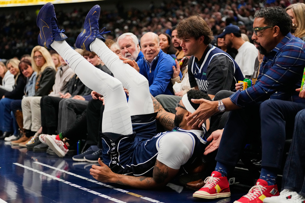 Dallas Mavericks forward Anthony Davis takes a spill in the first half of an NBA basketball game against the Brooklyn Nets in Dallas, Friday, Dec. 12, 2025. (AP Photo/Tony Gutierrez)