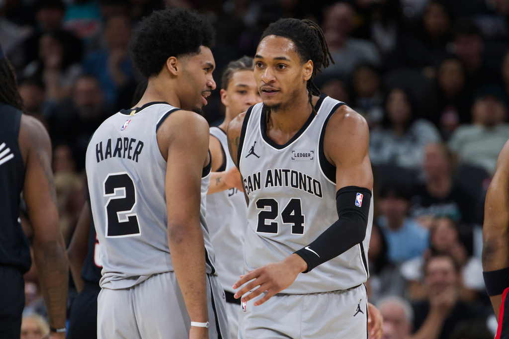 San Antonio Spurs guard Devin Vassell (24) celebrates a basket with teammate Dylan Harper during the first half of their NBA basketball game against the Portland Trail Blazers, Wednesday, April 8, 2026, in San Antonio. (AP Photo/Darren Abate)