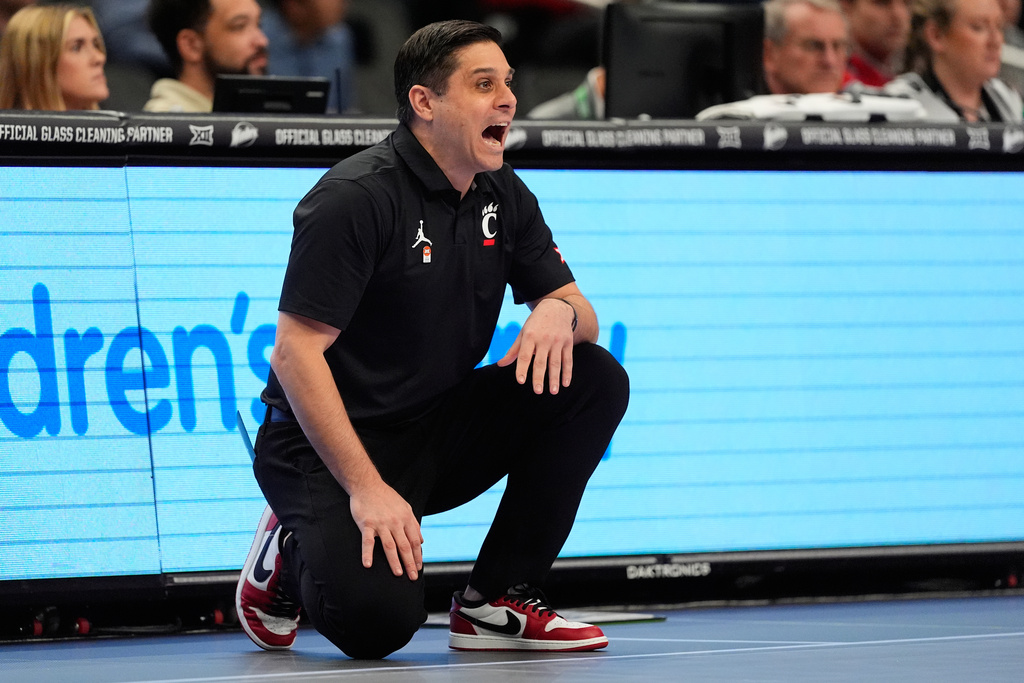 Cincinnati head coach Wes Miller talks to his players during the first half of an NCAA college basketball game against Utah at the Big 12 Conference tournament Tuesday, March 10, 2026, in Kansas City, Mo. (AP Photo/Charlie Riedel)