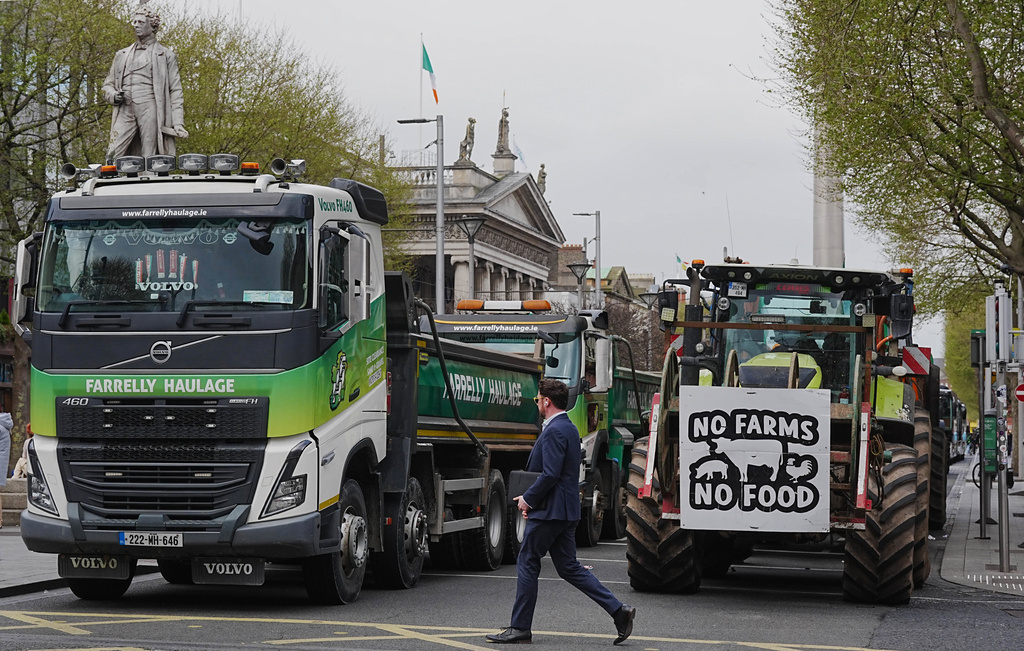 A man crosses a road where vehicles are parked on O'Connell Street, on the second day of a national fuel protest against rising fuel prices, in Dublin, Ireland, Wednesday April 8, 2026. (Brian Lawless/PA via AP)