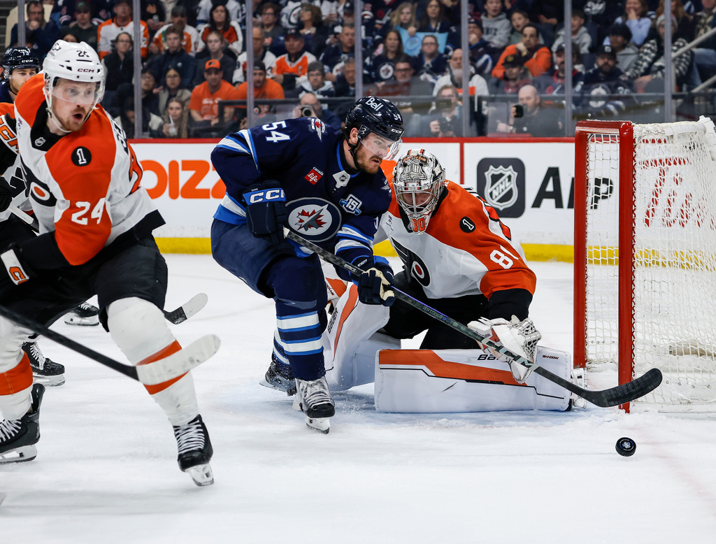 Philadelphia Flyers goaltender Dan Vladar (80) saves the shot from Winnipeg Jets' Dylan Samberg (54) during second period NHL action in Winnipeg, Saturday, April 11, 2026. (John Woods/The Canadian Press via AP)