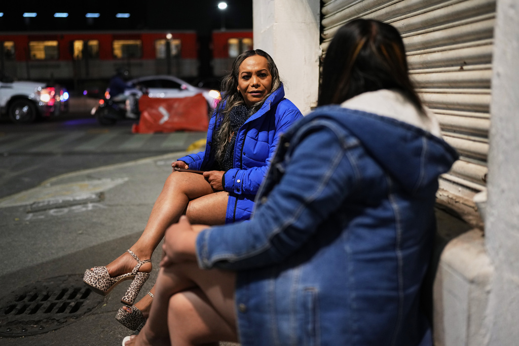 Montserrat Fuentes, left, speaks with a fellow sex worker on Calzada de Tlalpan where she has worked for 20 years and the city is building a bike lane that blocks cars from pulling over and closes the metro at night, in Mexico City, Friday, Jan. 30, 2026. (AP Photo/Eduardo Verdugo)