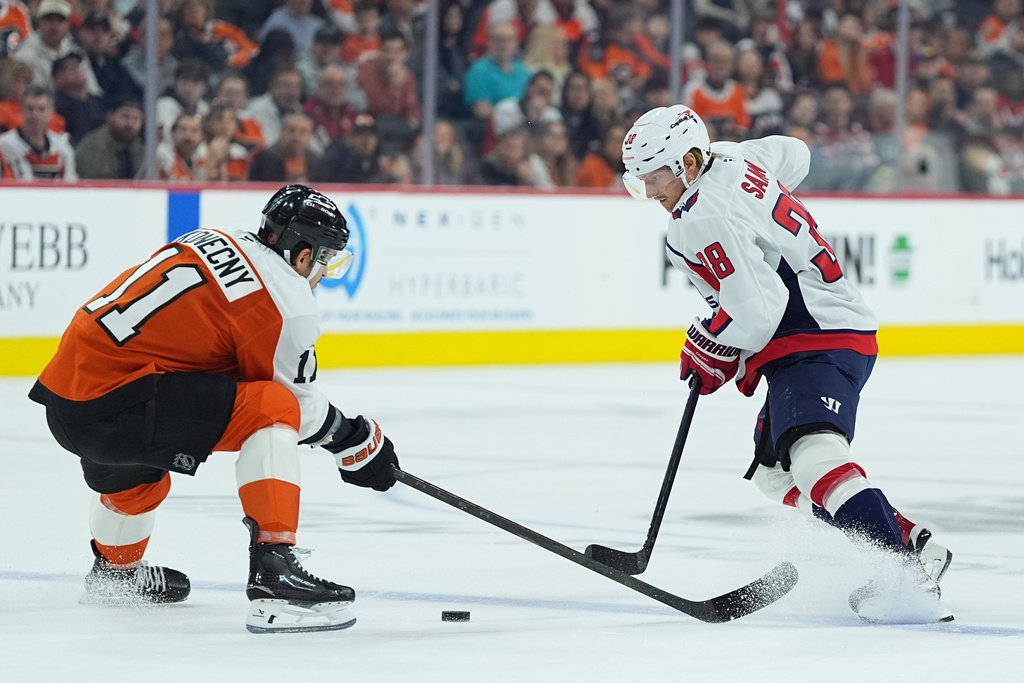 Washington Capitals' Rasmus Sandin tries to get the puck past Philadelphia Flyers' Travis Konecny during the first period of an NHL hockey game, Wednesday, March 11, 2026, in Philadelphia. (AP Photo/Matt Rourke)