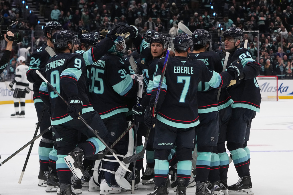 The Seattle Kraken celebrate a win in overtime on a goal by Vince Dunn against the Los Angeles Kings in an NHL hockey game Wednesday, Dec. 10, 2025, in Seattle. (AP Photo/Lindsey Wasson)