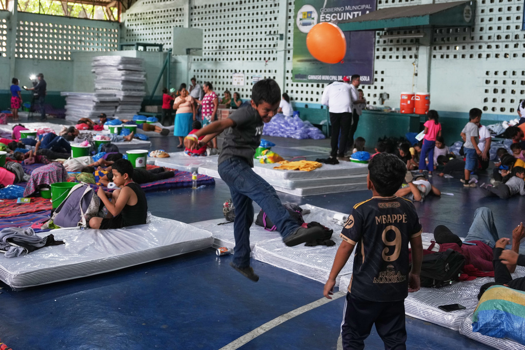 Children evacuated from El Porvenir, a village on the slopes of the Fuego volcano, play inside a temporary shelter in Escuintla, Guatemala, Tuesday, Aug. 4, 2026. (AP Photo/Moises Castillo)