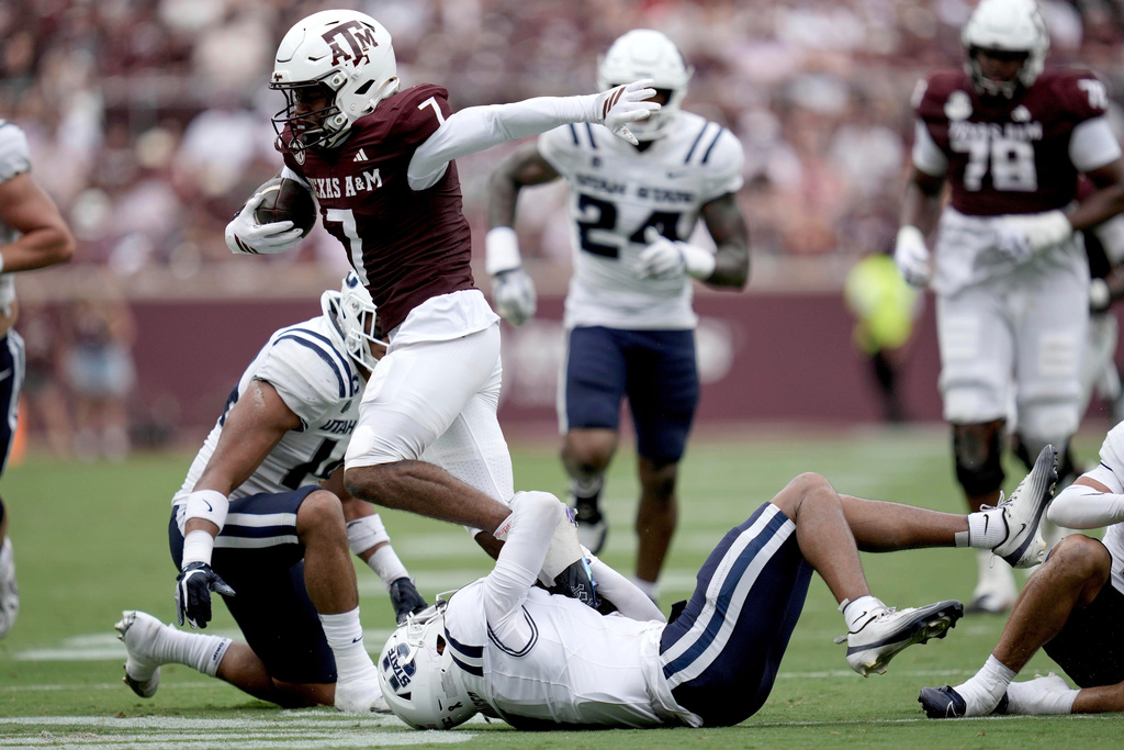 Texas A&M wide receiver KC Concepcion (7) is tackled by Utah State cornerback Noah Avinger (1) after a catch and run during the first quarter of an NCAA college football game Saturday, Sept. 6, 2025, in College Station, Texas. (AP Photo/Sam Craft)
