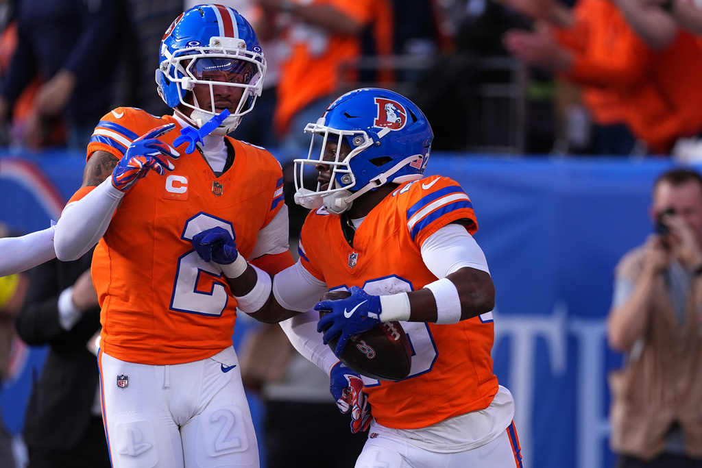 Denver Broncos cornerback Ja'quan McMillian, right, celebrates with cornerback Pat Surtain II (2) after scoring a touchdown on an interception against the Los Angeles Chargers in the first half of an NFL football game Sunday, Jan. 4, 2026, in Denver. (AP Photo/David Zalubowski)