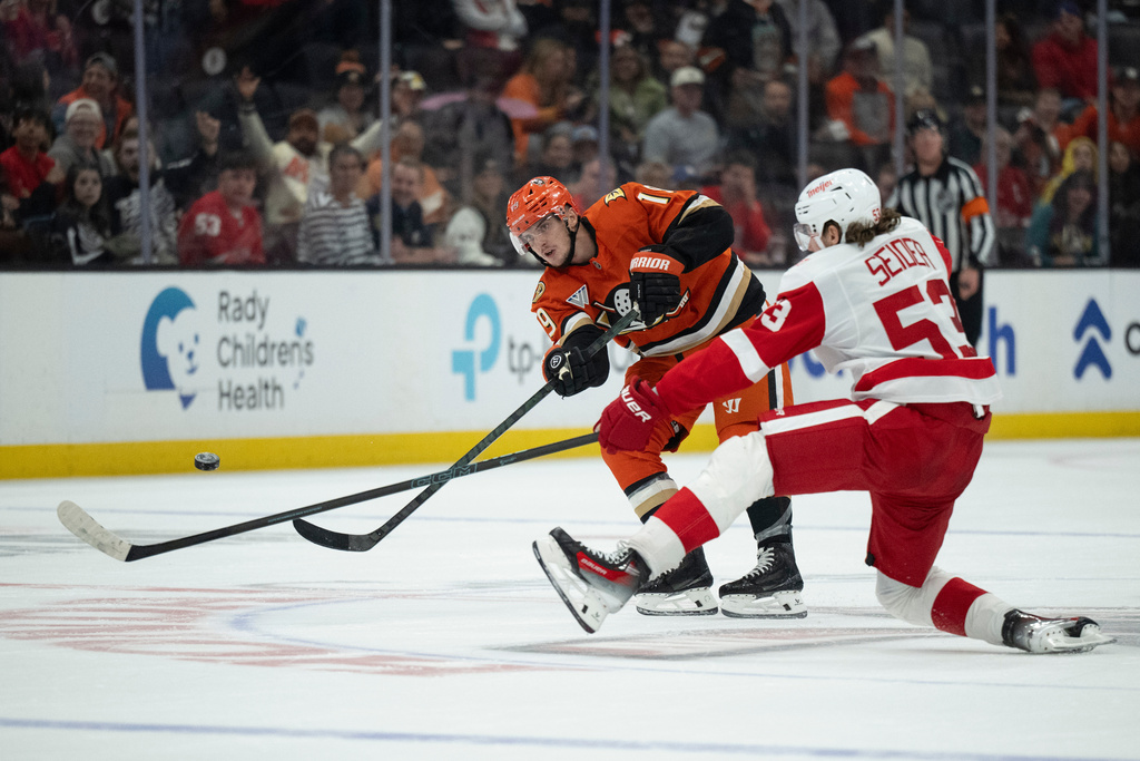 Anaheim Ducks right wing Troy Terry (19) shoots for an empty-net goal against Detroit Red Wings defenseman Moritz Seider (53) during the third period of an NHL hockey game, Friday, Oct. 31, 2025, in Anaheim, Calif. (AP Photo/Kyusung Gong)