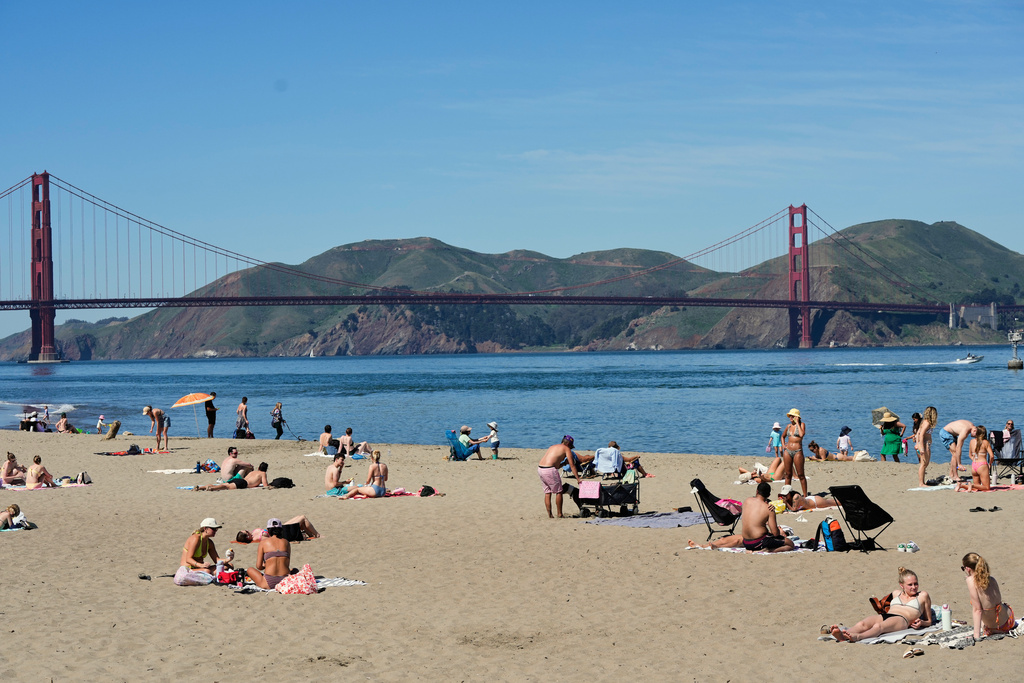 People lounge in the sand at Crissy Field East Beach backdropped by the Golden Gate Bridge in San Francisco, Tuesday, March 17, 2026. (AP Photo/Godofredo A. Vásquez)